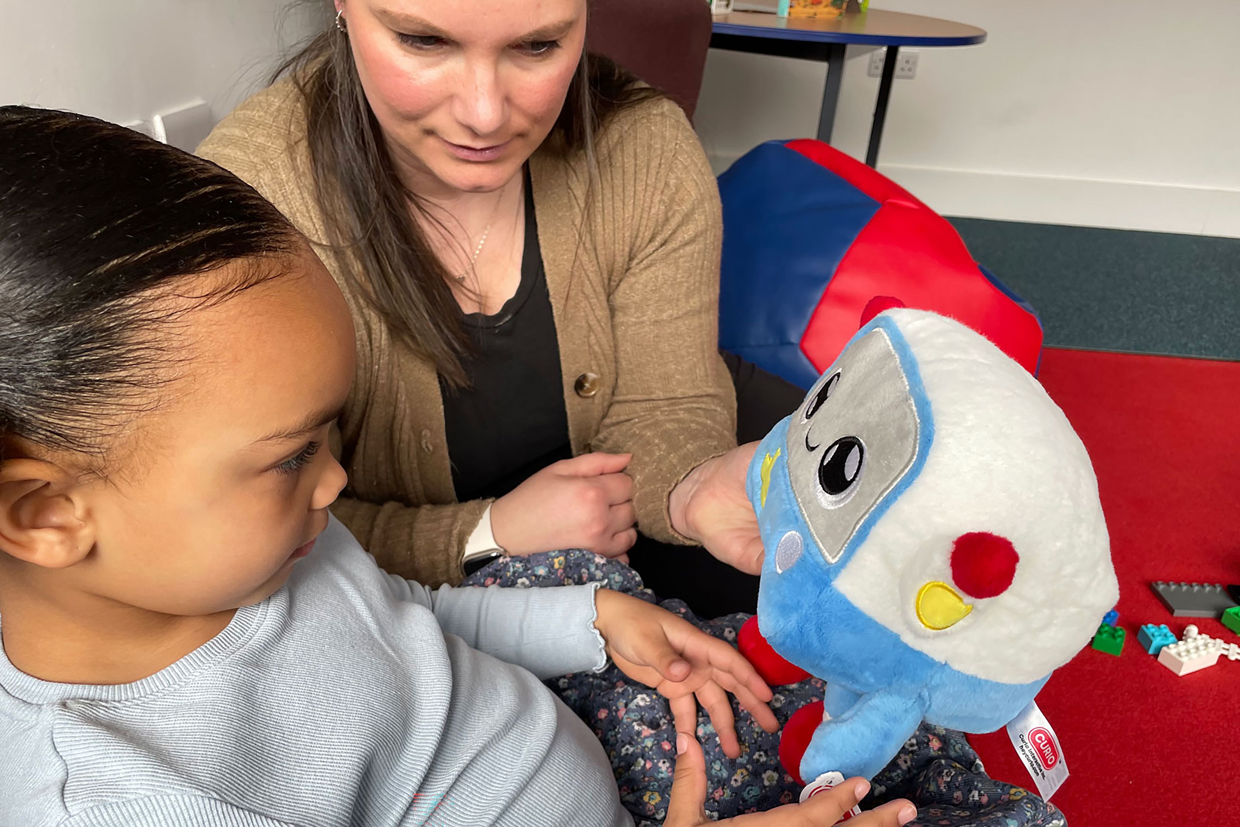 Mum and child playing with AI toy